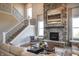 Cozy living room showcases a stone fireplace, staircase, modern decor, and an abundance of natural light at 7032 Portico Ln, McCordsville, IN 46055