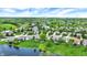 An aerial view showcases a neighborhood with lush green trees, manicured lawns, a pond, and varying home designs at 7110 Koldyke Dr, Fishers, IN 46038