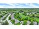 Aerial view of a residential area featuring a golf course, mature trees, and well-maintained homes at 7110 Koldyke Dr, Fishers, IN 46038