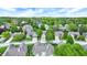 An aerial view shows a neighborhood with mature trees, well-manicured lawns, and various home styles at 7110 Koldyke Dr, Fishers, IN 46038