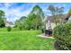 Expansive backyard with lush greenery, an outdoor patio and dining set, and mature trees at 7110 Koldyke Dr, Fishers, IN 46038
