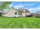 A large, manicured backyard features a patio area with dining furniture and a fountain at 7110 Koldyke Dr, Fishers, IN 46038