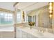 This spacious bathroom offers dual sinks, a large mirror with lighting, and floral wallpaper at 7110 Koldyke Dr, Fishers, IN 46038