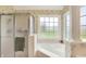 Bright bathroom featuring a soaking tub surrounded by windows, shower and a tile floor at 7110 Koldyke Dr, Fishers, IN 46038