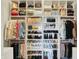 Organized walk-in closet with shelves and hanging rods for ample storage of clothes, shoes and accessories at 7110 Koldyke Dr, Fishers, IN 46038