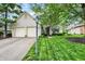 Well-maintained white brick home featuring an attached two-car garage, green lawn and mature trees at 7110 Koldyke Dr, Fishers, IN 46038