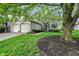 Charming brick home featuring a well-manicured lawn, mature trees, and an attached two-car garage at 7110 Koldyke Dr, Fishers, IN 46038