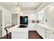 Bright eat-in kitchen featuring a cooktop island, hardwood floors, and white cabinets at 7110 Koldyke Dr, Fishers, IN 46038