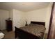 Simple bedroom with a wood-framed bed, dark dresser and carpeted floor at 7303 Beal Ln, Indianapolis, IN 46217