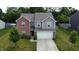 Two story home featuring a two car garage, red brick and gray siding, set in a green, tree filled yard at 7303 Beal Ln, Indianapolis, IN 46217