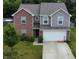 Charming two-story home featuring a brick facade, gray siding, attached garage, and a well-manicured lawn at 7303 Beal Ln, Indianapolis, IN 46217