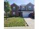 Two-story home showcasing brick and gray siding, attached two car garage and well-maintained lawn at 7303 Beal Ln, Indianapolis, IN 46217