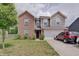 Attractive two-story home with a brick and siding facade, a two-car garage, and a well-manicured lawn at 7303 Beal Ln, Indianapolis, IN 46217