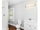 This bathroom features a sink with vanity, toilet, window with blinds, and tiled shower at 736 N Dequincy St, Indianapolis, IN 46201