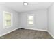 Bright bedroom with neutral carpet, two windows, and soft gray walls at 736 N Dequincy St, Indianapolis, IN 46201