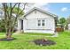 Charming white-painted brick home with green lawn, mature trees, and inviting entrance, blending classic charm with curb appeal at 736 N Dequincy St, Indianapolis, IN 46201