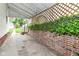 Covered patio featuring a brick wall adorned with ivy, offering a private outdoor space for relaxation and entertainment at 736 N Dequincy St, Indianapolis, IN 46201