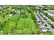 An aerial view presents an expansive grassy field bordered by lush trees and a variety of buildings, highlighting a versatile landscape at 7425 E Thompson Rd, Indianapolis, IN 46239