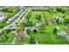 An aerial view displays a residence situated on a vast green lawn, with neighboring houses and a tranquil pond nearby at 7425 E Thompson Rd, Indianapolis, IN 46239