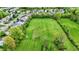 An aerial perspective captures a vast, well-maintained lawn bordered by a pond and residential area, showcasing a blend of nature and community at 7425 E Thompson Rd, Indianapolis, IN 46239