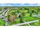 A picturesque aerial view shows a home with a sprawling lawn, mature trees, and a charming red barn amidst a serene, rural landscape at 7425 E Thompson Rd, Indianapolis, IN 46239