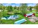 Picturesque aerial view showcasing a beautiful pond, a red barn, and lush greenery, with a shipping container on the property at 7425 E Thompson Rd, Indianapolis, IN 46239