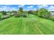 High angle shot showing an extensive green lawn dotted with trees and bordered by residential homes, creating a tranquil and spacious setting at 7425 E Thompson Rd, Indianapolis, IN 46239