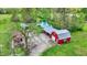 Stunning aerial view of the property featuring a charming red barn, pond with dock and a cabin surrounded by lush greenery at 7425 E Thompson Rd, Indianapolis, IN 46239