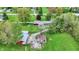 Overhead perspective of the property, featuring a home, a red barn, a cabin, manicured lawns, and mature trees at 7425 E Thompson Rd, Indianapolis, IN 46239