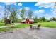 Spacious backyard with outdoor seating area, fire pit, and outbuildings under blue skies at 7425 E Thompson Rd, Indianapolis, IN 46239