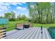 View of the backyard featuring a pond with a deck and a beautiful green lawn at 7425 E Thompson Rd, Indianapolis, IN 46239