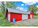 Exterior view of a red barn-style storage shed with white doors and trim at 7425 E Thompson Rd, Indianapolis, IN 46239