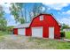 Close exterior of red barn featuring a metal roof and white garage doors on a large lot at 7425 E Thompson Rd, Indianapolis, IN 46239