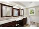 Inviting bathroom features dark wood vanities, dual sinks, mirrors, and tile flooring at 7425 E Thompson Rd, Indianapolis, IN 46239