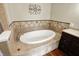 Modern bathroom showcasing a luxurious built-in tub with tile surround and dark wood vanity at 7425 E Thompson Rd, Indianapolis, IN 46239