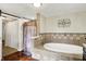 A stylish bathroom featuring a soaking tub, shower, vanity with dark cabinets, and unique wall decor at 7425 E Thompson Rd, Indianapolis, IN 46239