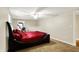 Comfortable bedroom features a bed with red bedding, ceiling fan, and natural light at 7425 E Thompson Rd, Indianapolis, IN 46239