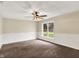 Bright bedroom featuring a ceiling fan, soft carpet, and a large window with pleasant views at 7425 E Thompson Rd, Indianapolis, IN 46239