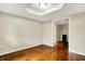 A large, empty bedroom has neutral walls and shiny hardwood floors at 7425 E Thompson Rd, Indianapolis, IN 46239
