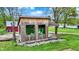 Exterior shot of the wooded cabin featuring rustic wood siding, large windows and a covered porch nestled in a serene setting at 7425 E Thompson Rd, Indianapolis, IN 46239