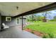 View from the covered patio to the spacious lawn and outbuildings on this lovely property at 7425 E Thompson Rd, Indianapolis, IN 46239