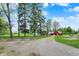 Long driveway leading to a home and outbuildings on a well-treed lot at 7425 E Thompson Rd, Indianapolis, IN 46239