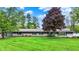 Charming single-story home with a well-manicured lawn and mature trees at 7425 E Thompson Rd, Indianapolis, IN 46239