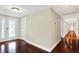 Bright hallway with hardwood floors leading to a glass-paneled entry door at 7425 E Thompson Rd, Indianapolis, IN 46239
