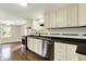 A well-lit kitchen features white cabinets, modern stainless steel appliances, and updated tile backsplash at 7425 E Thompson Rd, Indianapolis, IN 46239