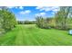 Expansive grassy lawn perfect for outdoor activities and recreation with the blue sky and scattered trees providing a scenic backdrop at 7425 E Thompson Rd, Indianapolis, IN 46239