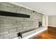 Close up of a decorative stone fireplace with black mantle and hardwood flooring at 7425 E Thompson Rd, Indianapolis, IN 46239