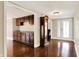 Spacious living room with dark wood floors, built-in cabinets, and a view of the front entrance at 7425 E Thompson Rd, Indianapolis, IN 46239