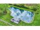 A serene pond featuring a modern deck, surrounded by lush greenery, creating a peaceful outdoor retreat at 7425 E Thompson Rd, Indianapolis, IN 46239