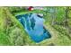 An aerial view showcases a serene pond, featuring clear water and a small dock, complemented by lush greenery and nearby buildings at 7425 E Thompson Rd, Indianapolis, IN 46239